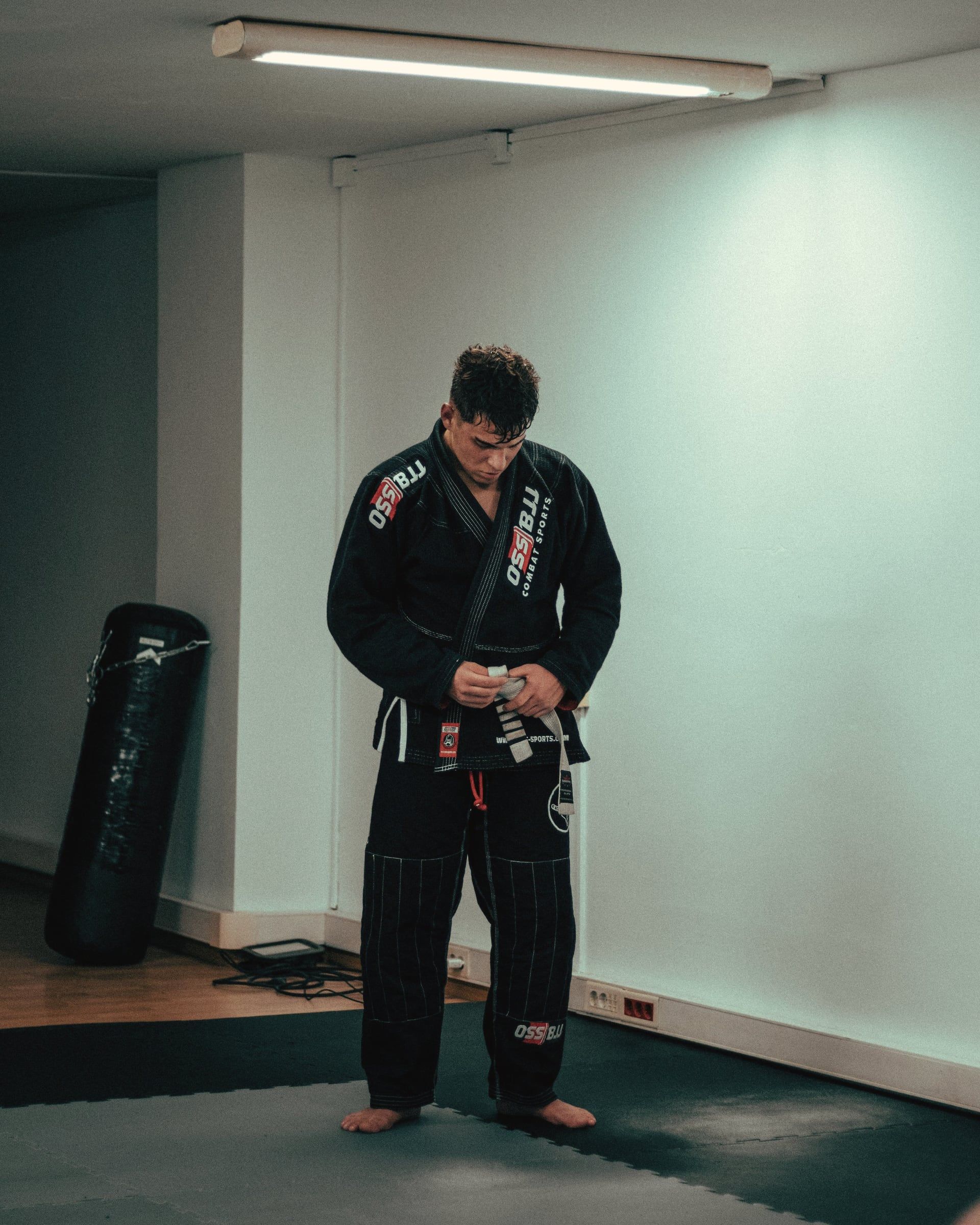 Praticante de jiu-jitsu amarrando a faixa antes do treino