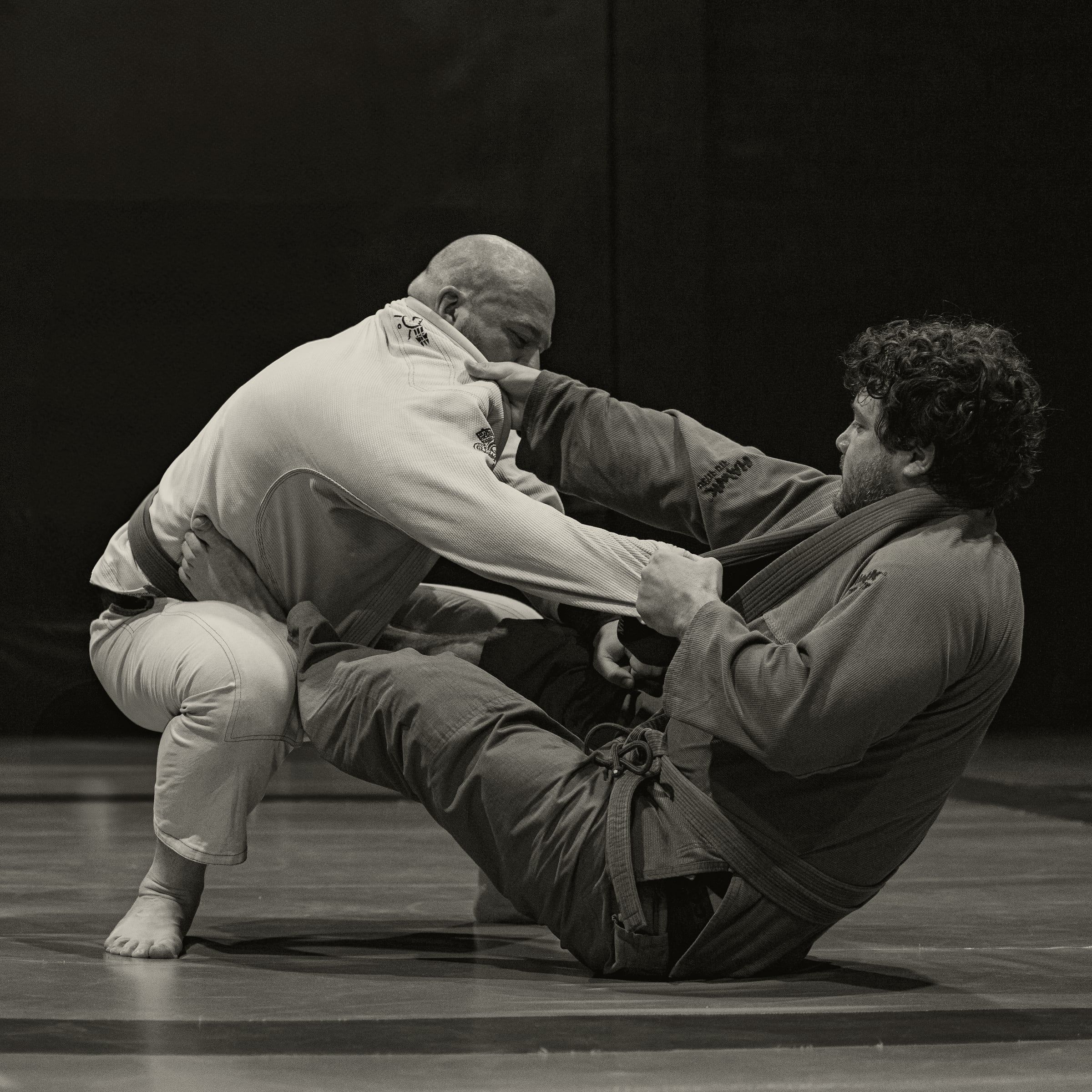 Mãos segurando a gola do kimono num treino de jiu-jitsu