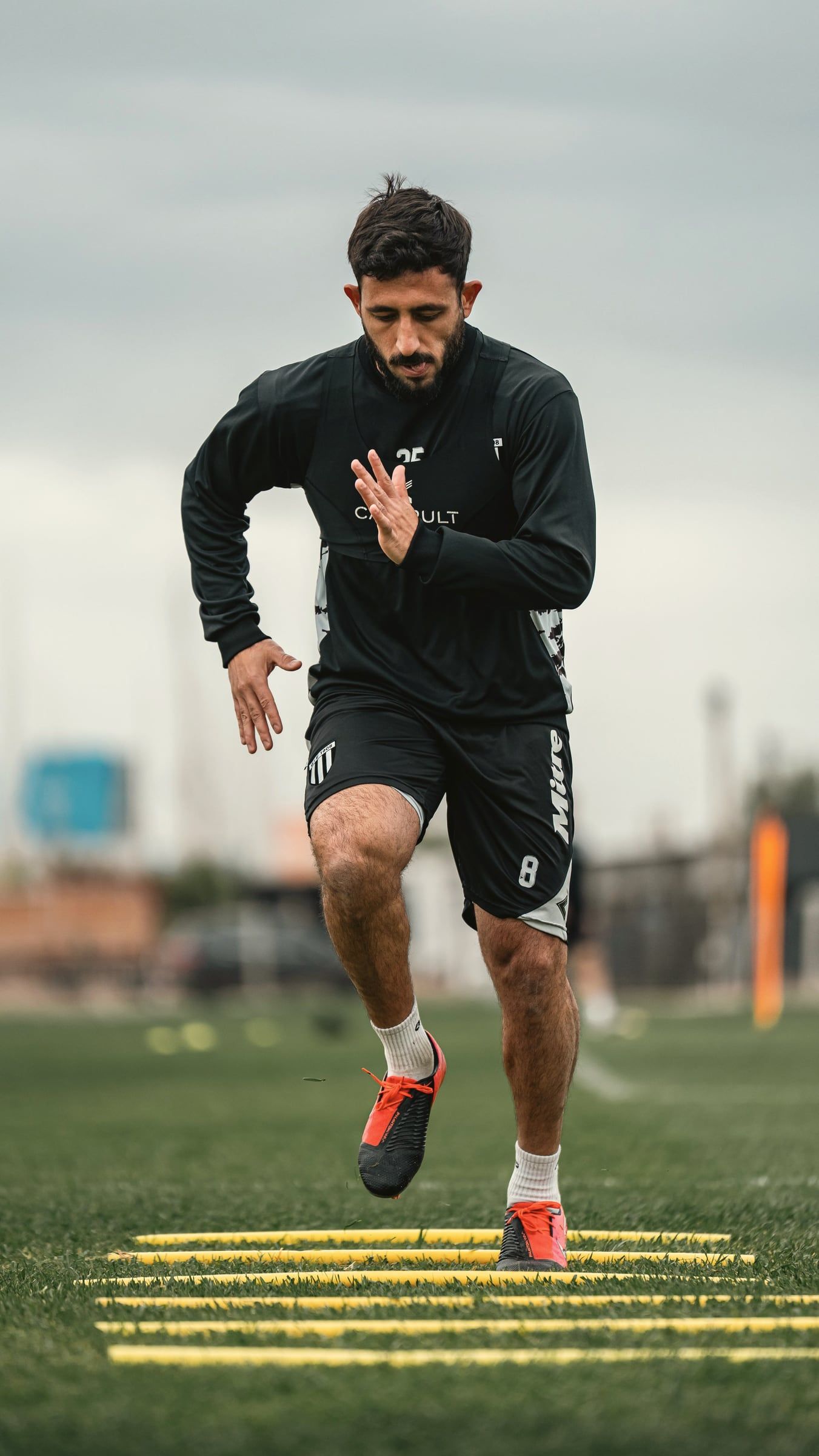Jogador de futebol fazendo treino de agilidade na escada de coordenação