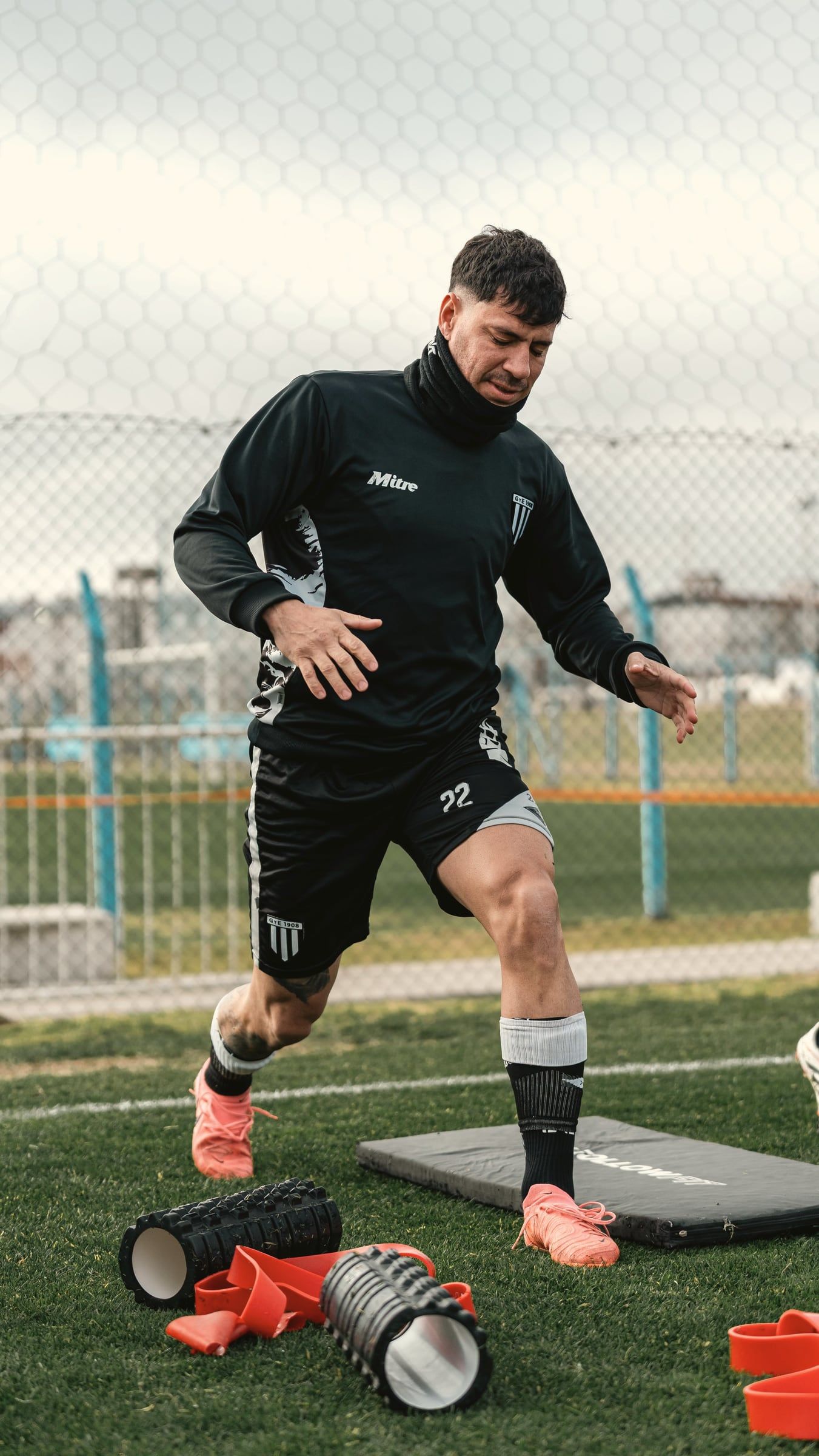 Jogador de futebol em treino de recondicionamento com materiais de recuperação
